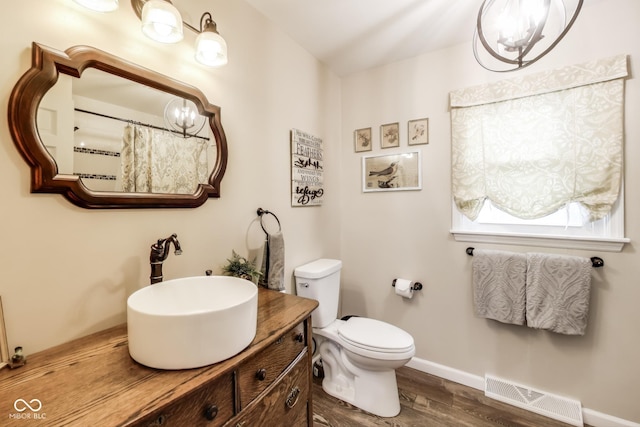 bathroom with vanity, toilet, and hardwood / wood-style floors