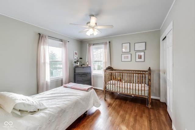 bedroom featuring hardwood / wood-style flooring, crown molding, ceiling fan, and a closet