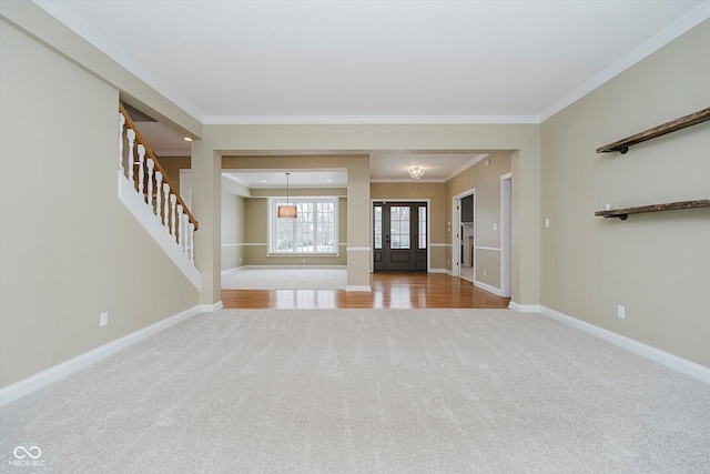 unfurnished living room featuring ornamental molding and carpet