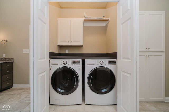 washroom with cabinets and washing machine and clothes dryer