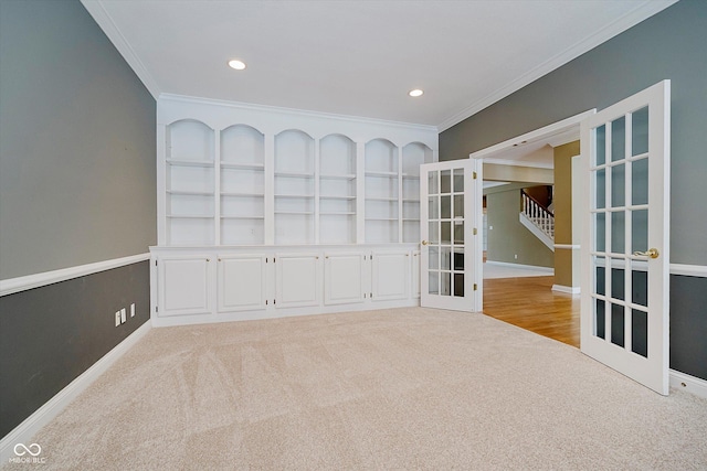 carpeted empty room with crown molding and french doors