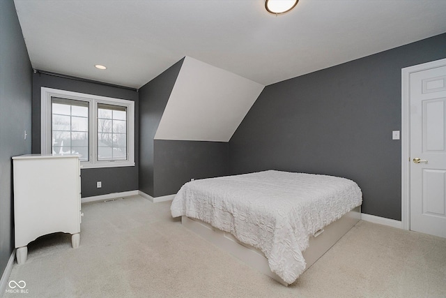 bedroom with lofted ceiling and light carpet