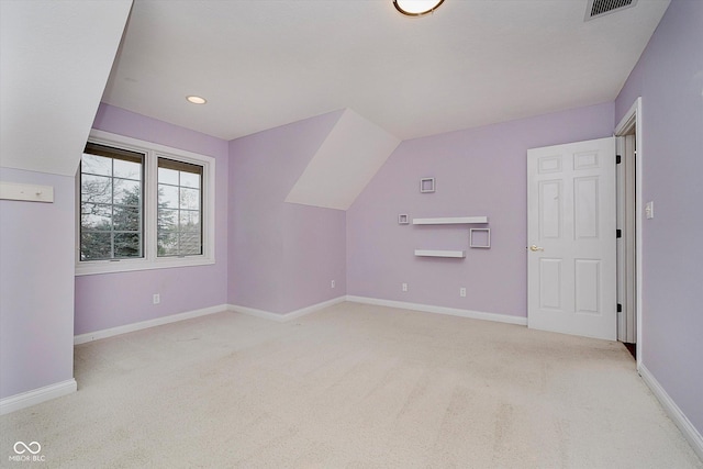 bonus room with light carpet and vaulted ceiling