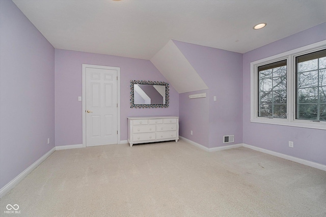 bonus room featuring lofted ceiling and light carpet