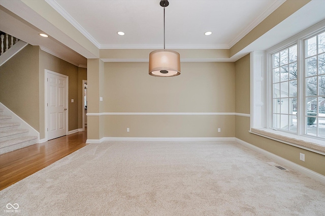 empty room with crown molding and carpet