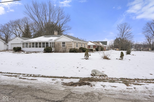 snow covered property featuring a sunroom