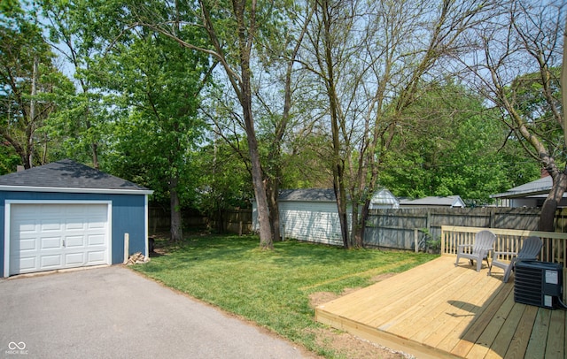 view of yard with a garage, an outbuilding, a deck, and central air condition unit