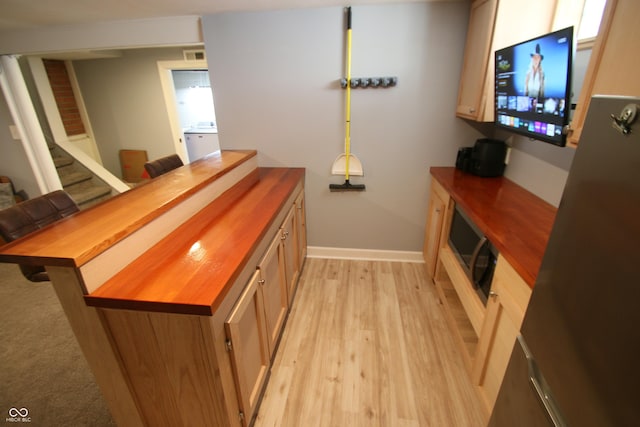 bar featuring wood counters and light wood-type flooring