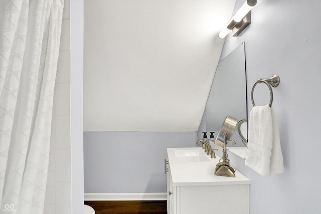 bathroom featuring vanity, hardwood / wood-style floors, a shower with curtain, and vaulted ceiling