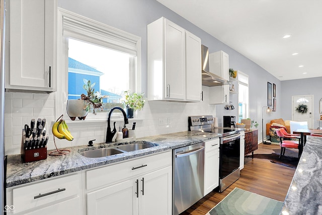 kitchen featuring stainless steel appliances, sink, white cabinets, and wall chimney exhaust hood