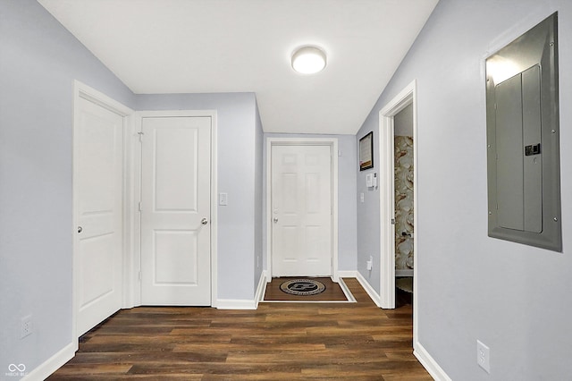 hall featuring lofted ceiling, dark wood-type flooring, and electric panel