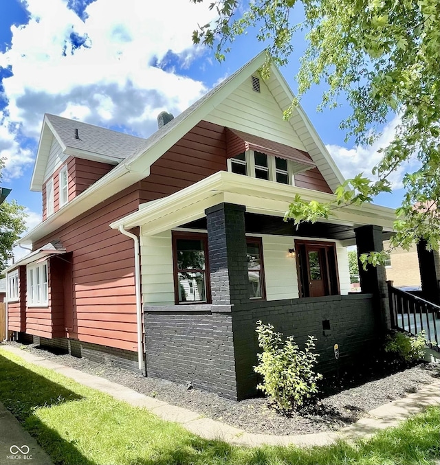 view of side of property featuring covered porch