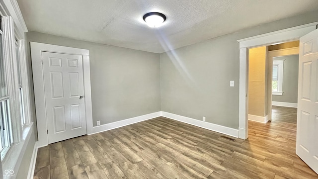 spare room featuring hardwood / wood-style flooring and a textured ceiling