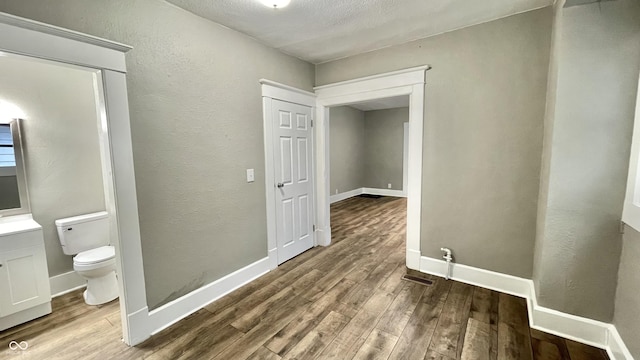 corridor with wood-type flooring and a textured ceiling