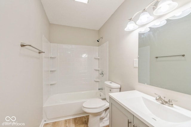 full bathroom featuring shower / washtub combination, hardwood / wood-style floors, vanity, toilet, and a textured ceiling