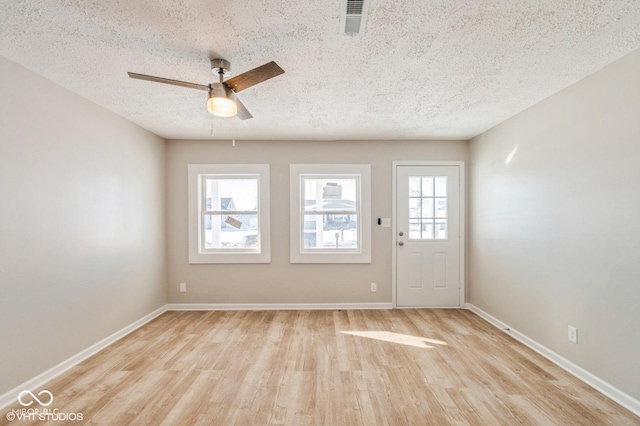 interior space featuring ceiling fan, a textured ceiling, and light hardwood / wood-style flooring