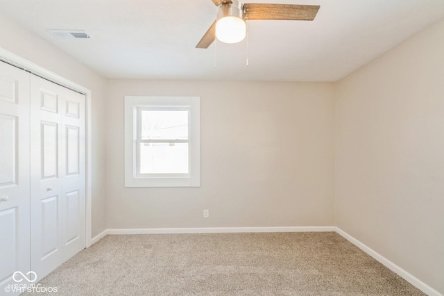 unfurnished bedroom with ceiling fan, light colored carpet, and a closet