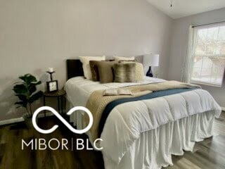 bedroom with hardwood / wood-style flooring and lofted ceiling