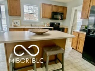 kitchen featuring a center island, sink, and black appliances