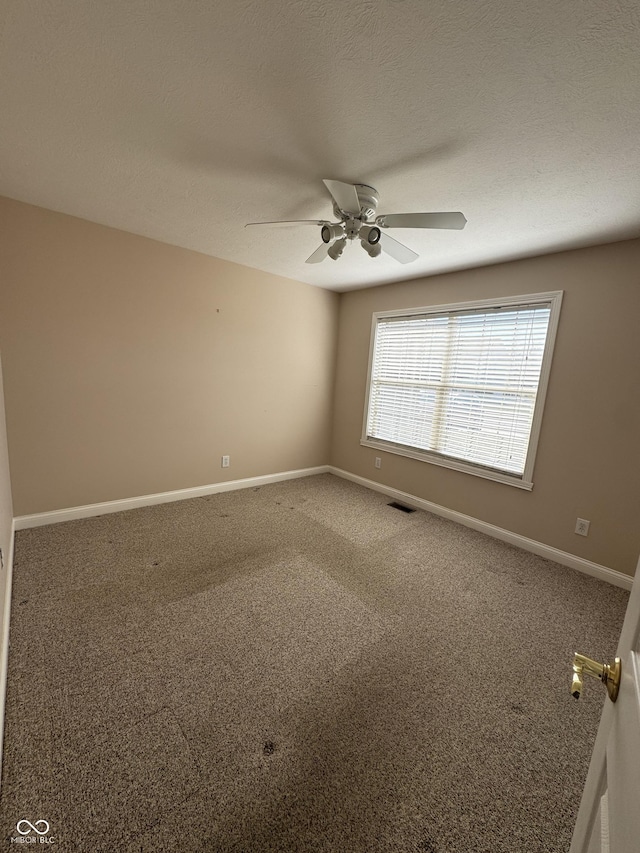 carpeted empty room featuring a textured ceiling and ceiling fan