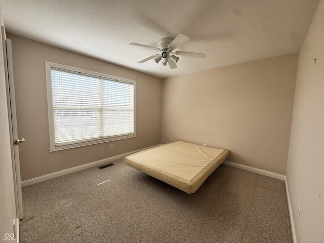 unfurnished bedroom featuring ceiling fan and carpet