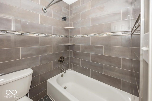 bathroom with tiled shower / bath, tile walls, and toilet