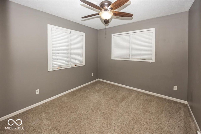 carpeted spare room featuring ceiling fan