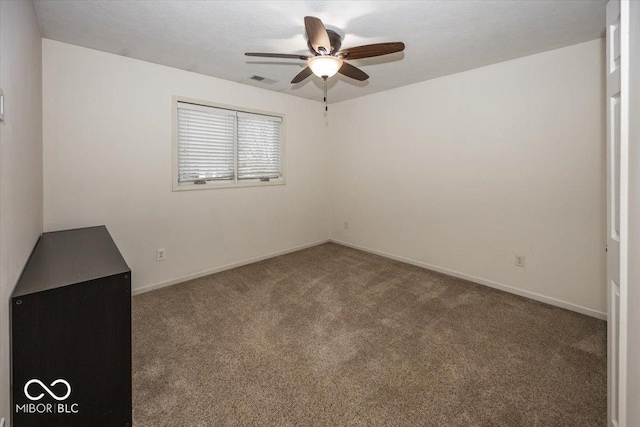 spare room with ceiling fan and carpet