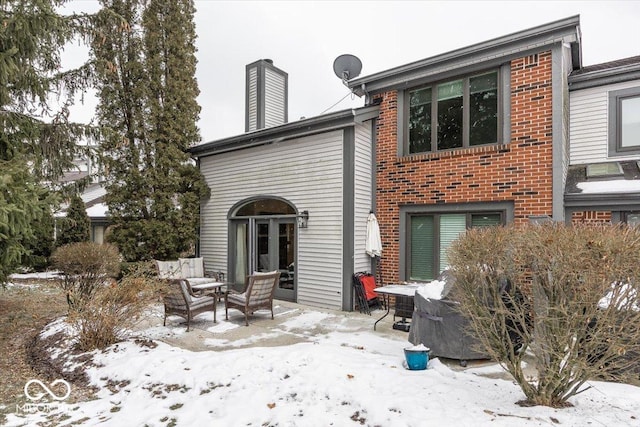 view of snow covered back of property