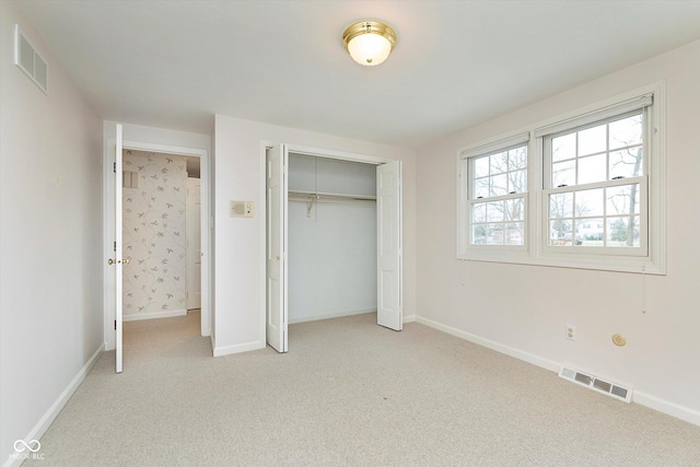 unfurnished bedroom with light carpet and a closet