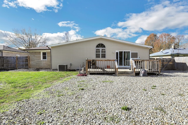 back of property featuring a wooden deck, central AC unit, and a yard