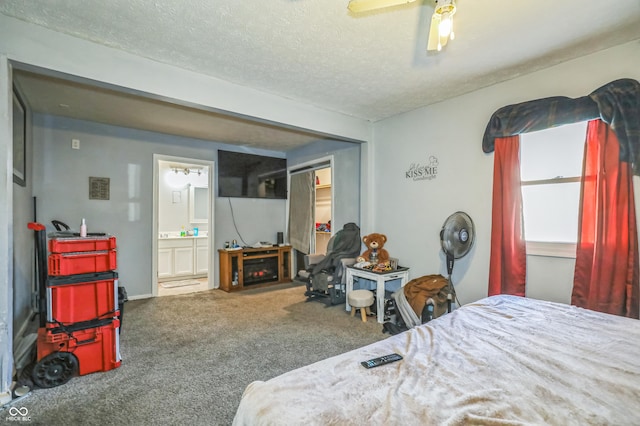 carpeted bedroom with connected bathroom, a textured ceiling, and ceiling fan