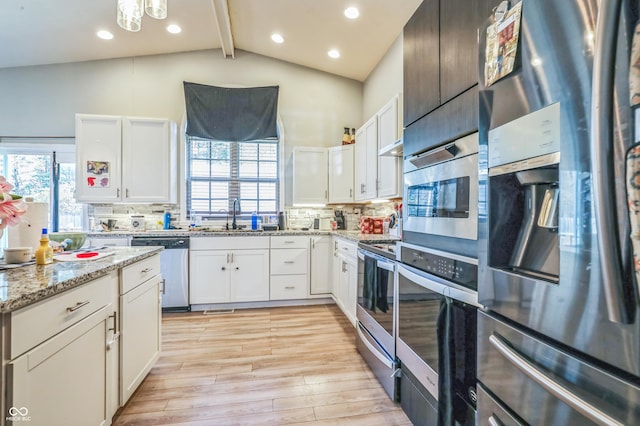 kitchen featuring white cabinetry, appliances with stainless steel finishes, light hardwood / wood-style floors, and decorative backsplash