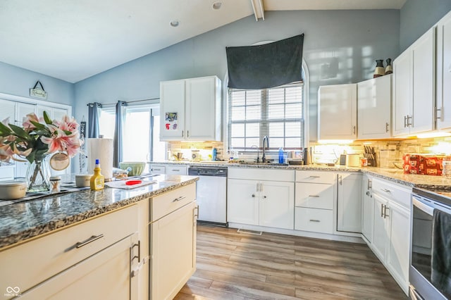 kitchen with sink, stone countertops, stainless steel appliances, light hardwood / wood-style floors, and white cabinets