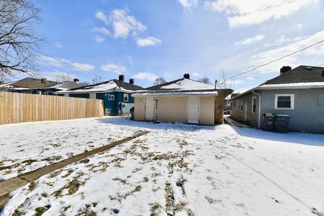 view of snow covered back of property