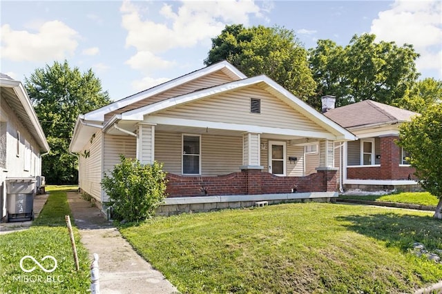 3614 E New York St, Indianapolis, IN 46201 - view of front facade featuring brick siding, a front lawn, and covered porch