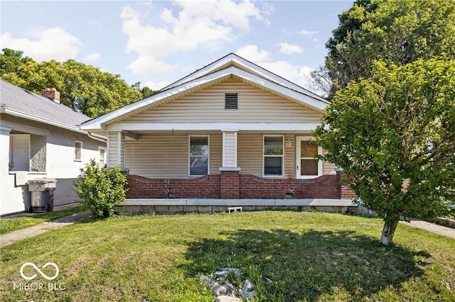 3614 E New York St, Indianapolis, IN 46201 - view of front of home with brick siding, covered porch, and a front yard
