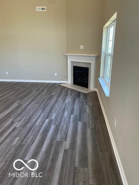 unfurnished living room with dark wood-type flooring