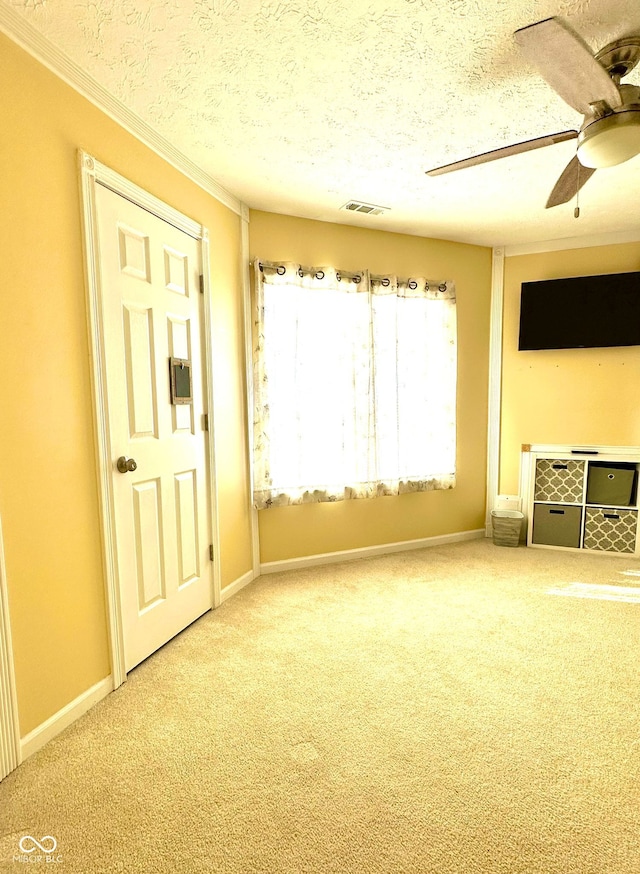 unfurnished living room featuring ceiling fan, carpet floors, and a textured ceiling