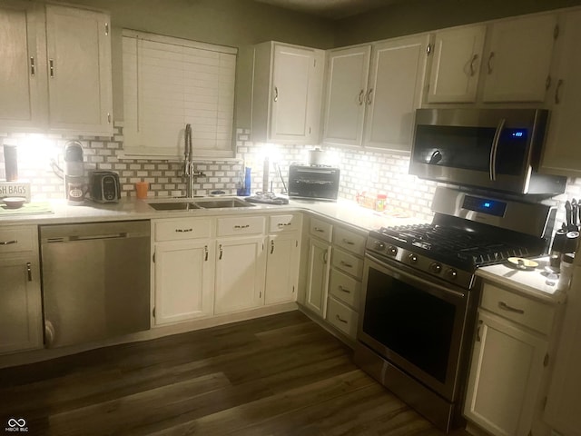 kitchen with sink, white cabinetry, stainless steel appliances, dark hardwood / wood-style flooring, and decorative backsplash