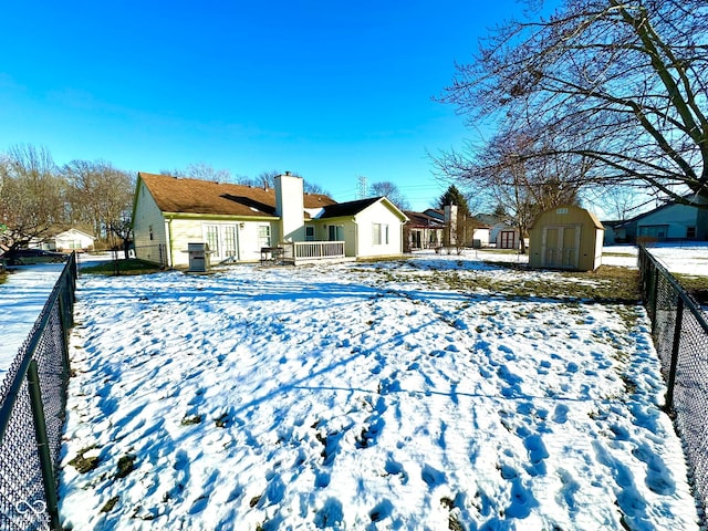 snow covered house featuring a storage unit