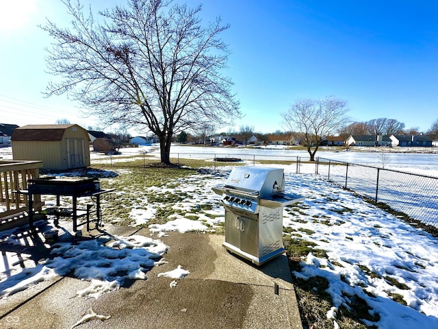 yard covered in snow with a storage unit