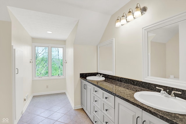 8602 Frontgate Ln, Indianapolis, IN 46256 - bathroom with tile patterned floors, double vanity, baseboards, and lofted ceiling