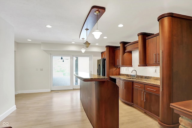 8602 Frontgate Ln, Indianapolis, IN 46256 - kitchen with a kitchen island, light wood finished floors, recessed lighting, baseboards, and freestanding refrigerator