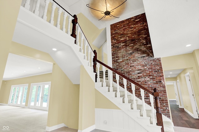 8602 Frontgate Ln, Indianapolis, IN 46256 - stairs with a towering ceiling, baseboards, wood finished floors, brick wall, and recessed lighting