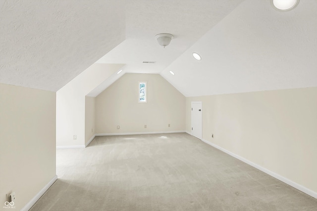 8602 Frontgate Ln, Indianapolis, IN 46256 - bonus room featuring light colored carpet, baseboards, lofted ceiling, a textured ceiling, and recessed lighting