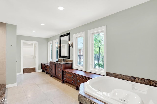 8602 Frontgate Ln, Indianapolis, IN 46256 - bathroom featuring a tub with jets, vanity, recessed lighting, tile patterned flooring, and baseboards