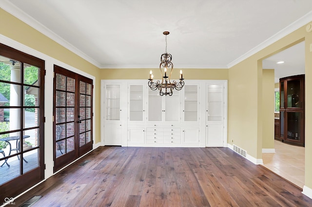 8602 Frontgate Ln, Indianapolis, IN 46256 - unfurnished dining area featuring french doors, a chandelier, dark wood-style flooring, baseboards, and ornamental molding