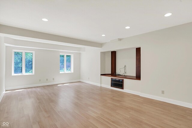 8602 Frontgate Ln, Indianapolis, IN 46256 - unfurnished living room featuring light wood-style flooring, baseboards, and recessed lighting