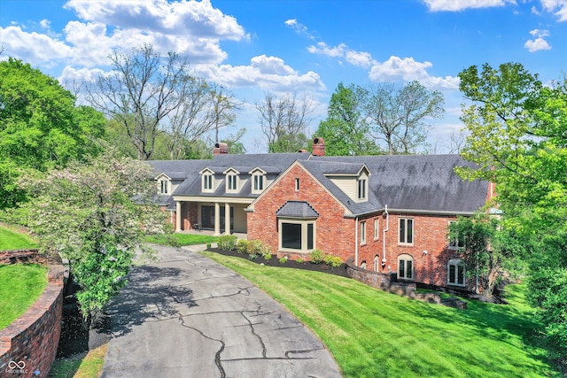 8602 Frontgate Ln, Indianapolis, IN 46256 - view of front of house featuring brick siding, a chimney, a front yard, and asphalt driveway